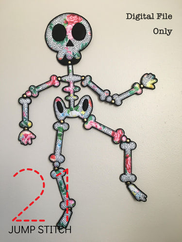 Embroidered felt skeleton on wall with black background and floral bones. The skeleton is 2 feet tall and held together with metal paper fasteners. In the top right corner it reads, 